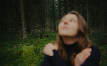 Persona neutra con occhi chiusi e mani sul petto in ascolto del corpo