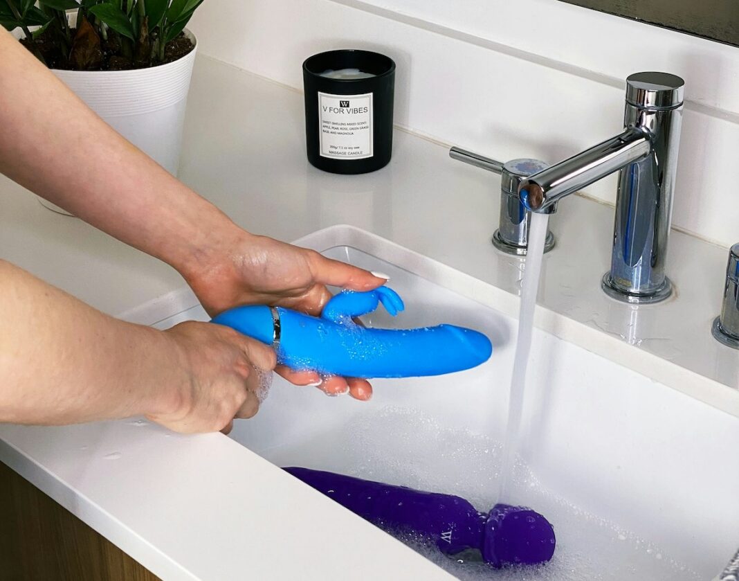 Mano che tiene un oggetto blu, immagine simbolica dedicata alla pulizia del vibratore e all’igiene dei sex toy