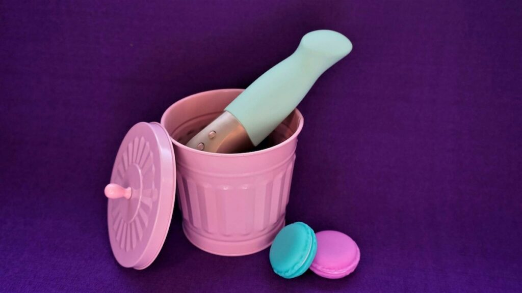 Contenitore rosa con manico in legno, immagine simbolica dedicata alla pulizia e conservazione del vibratore