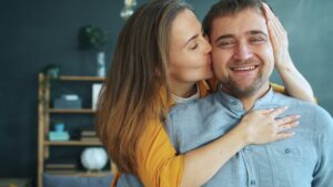 Coppia matura seduta sul divano che si guarda sorridendo