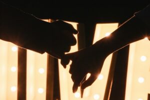 Due persone si tengono le mani in un gesto affettuoso